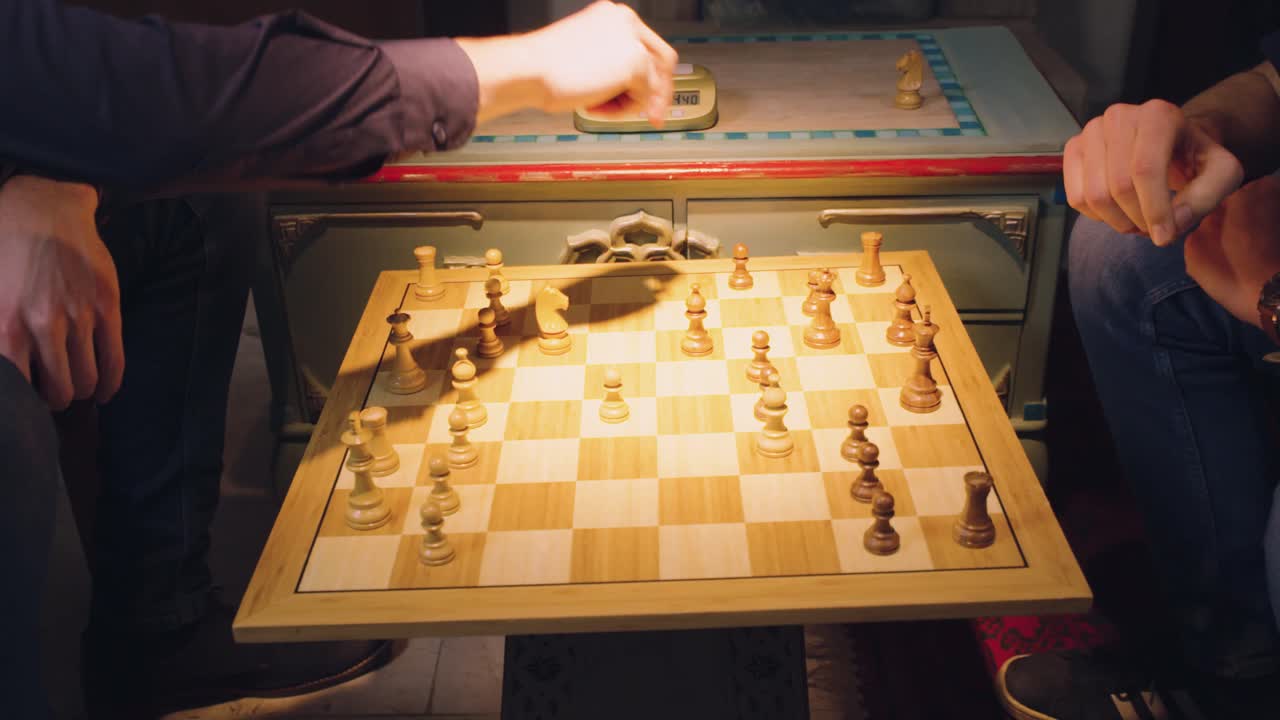 두 명의 체스 플레이어의 손이 조각을 번갈아 가며 체스 판에서 체스 조각을 가져옵니다.