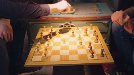 the hands of two chess players move the pieces alternately, taking some chess pieces off the chess board