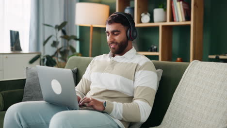 Man with Laptop and Headphones Relaxing on Couch at Home