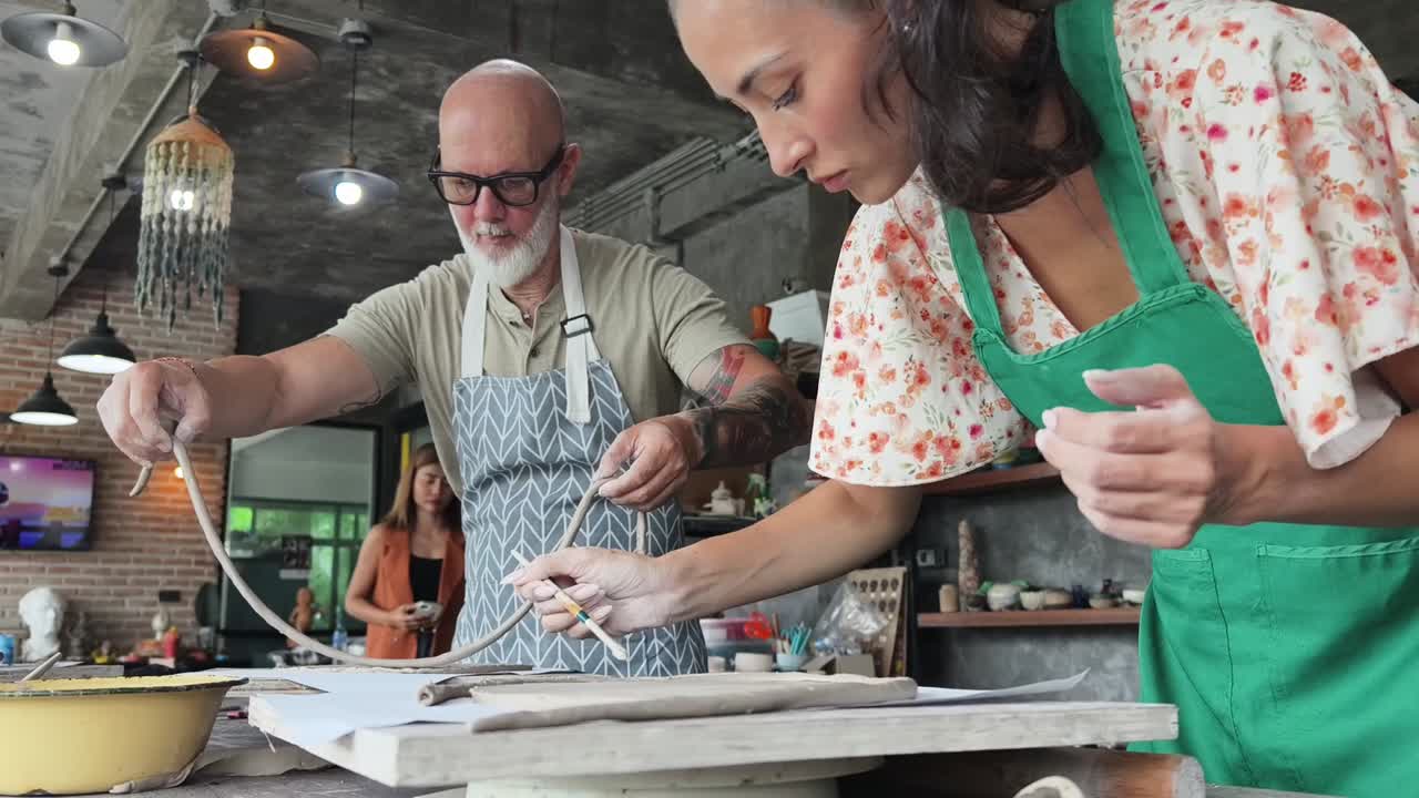 Man and Woman Sculpting Clay in Pottery Workshop