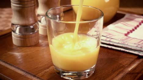 Orangensaft-In-Ein-Glas-Gießen,-Das-Morgendliche-Frühstück.-Zeitlupe-Mit-Rotierender-Kamerafahrt.