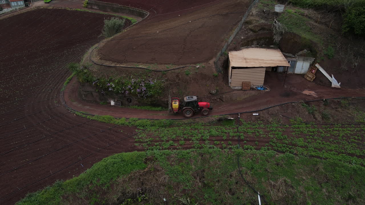 toma remota de un dron en un tractor que se mueve sobre plantaciones de papa