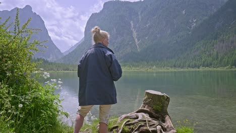 woman tourists solitary moment by scenic lake with mountain backdrop
