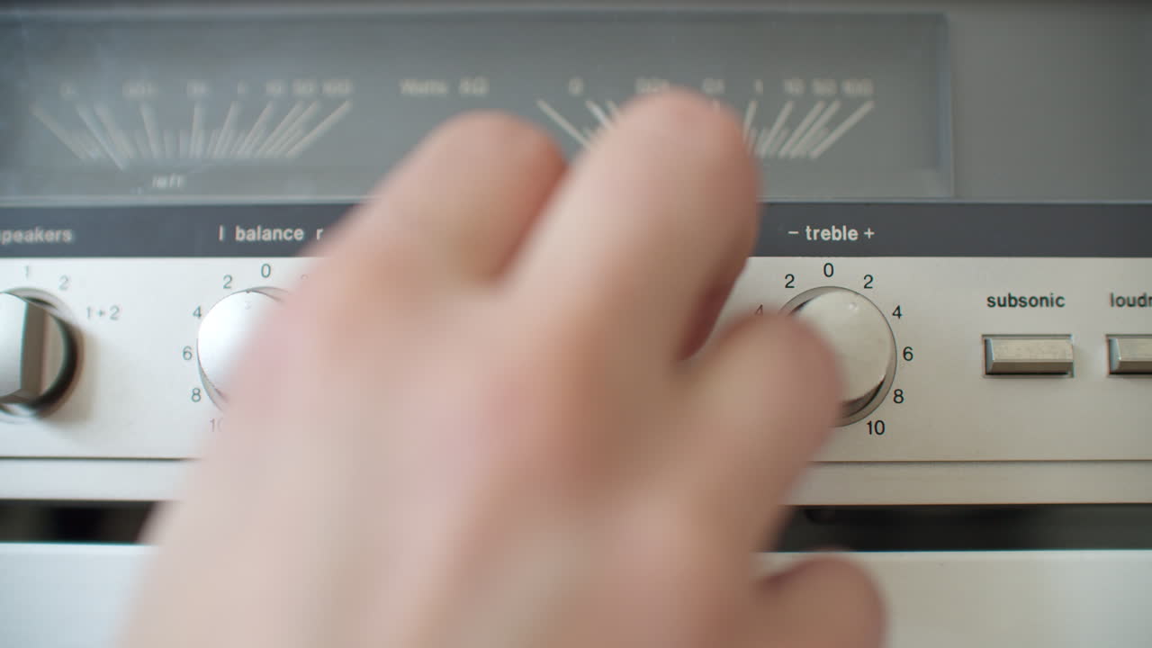 오른손으로 저음 손잡이를 조정하는 클로즈업 샷