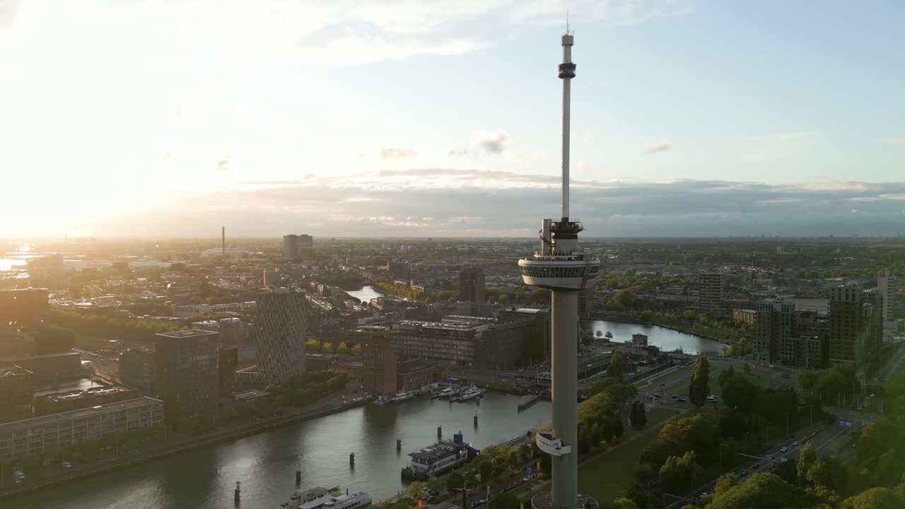 Drone footage of the Euromast observation tower and Rotterdam skyline during the golden hour sunset in summer