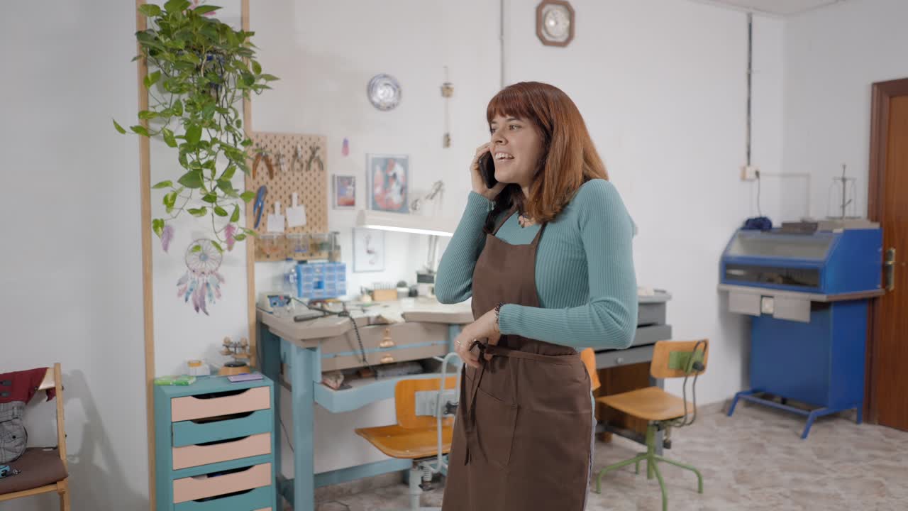 Woman talking on phone in jewelry workshop