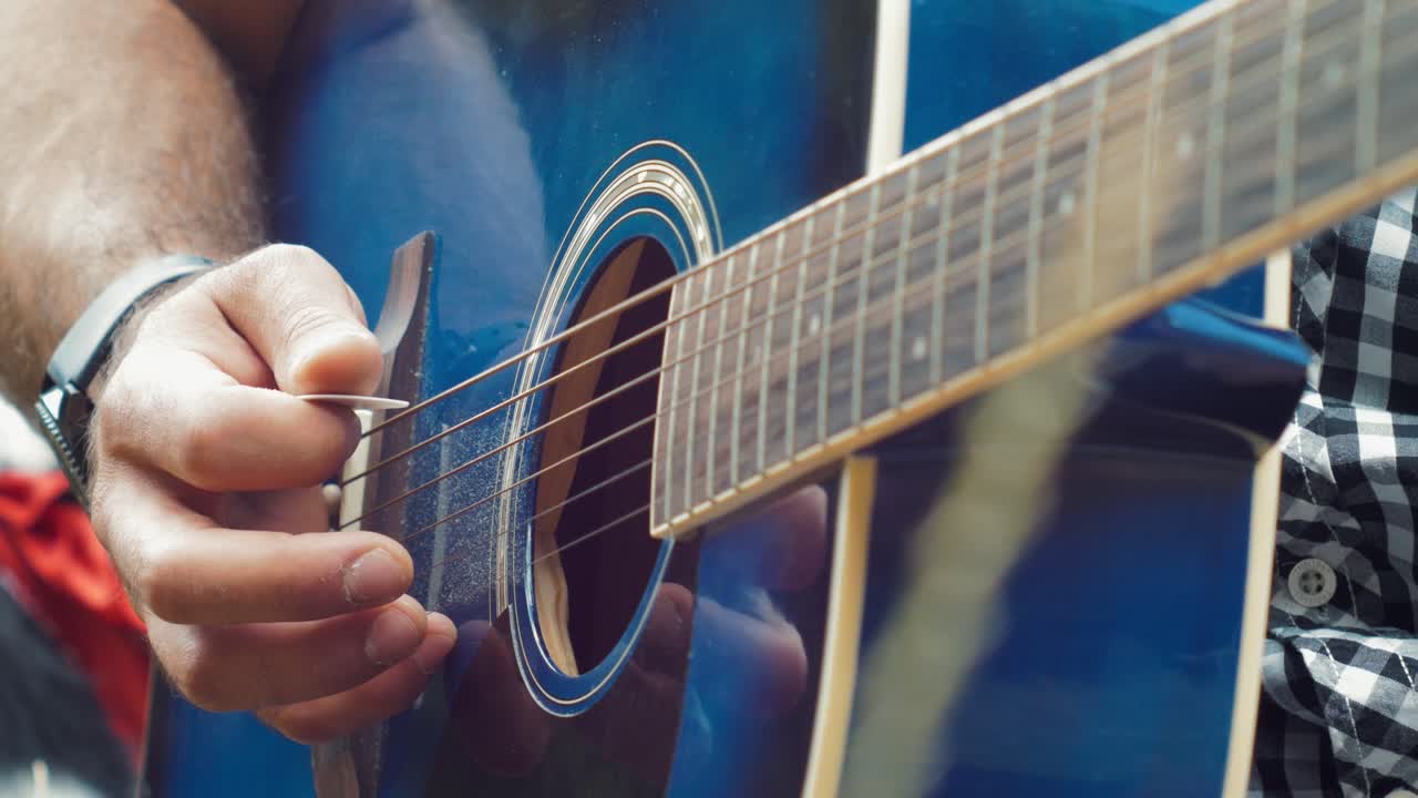 Guy strumming guitar slow motion
