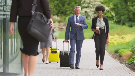 group of business delegates with luggage arriving at conference hotel