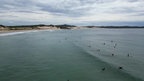 group of surfers waiting for the perfect moment at one mile beach nsw australia