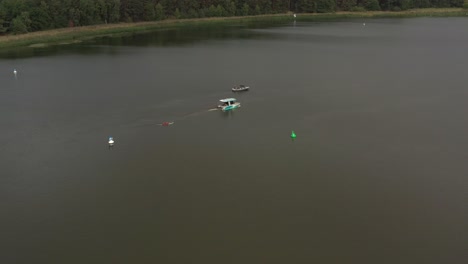 Tiro-De-Drone-De-Surfergirl-En-Longboard-Detrás-Del-Barco