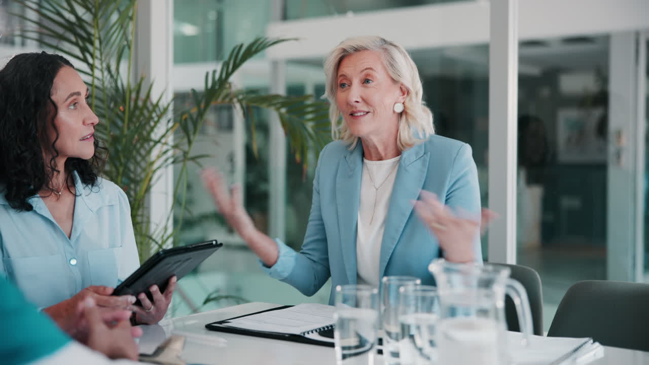 두 여성이 비즈니스 회의에서 손을 흔들고 있습니다.