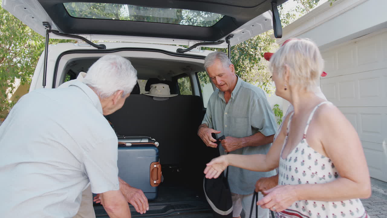 grupo de amigos mayores cargando equipaje en el maletero del coche a punto de irse de vacaciones