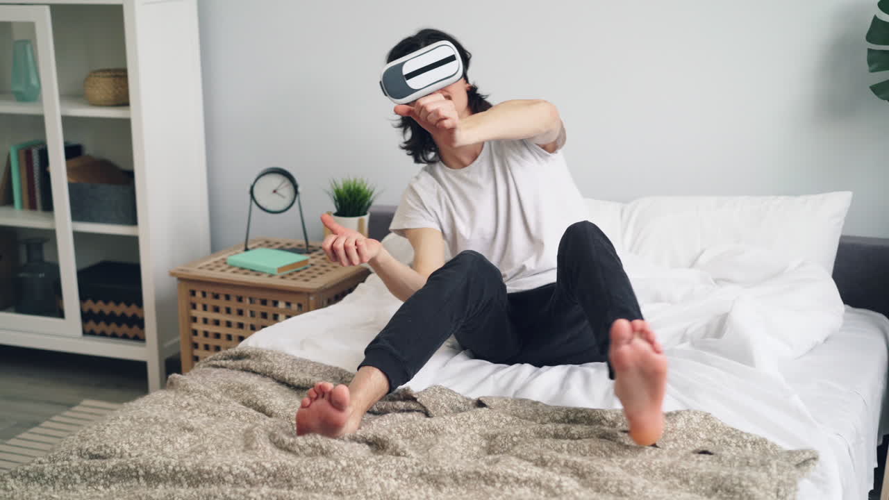 Man wearing VR headset playing a game in bed