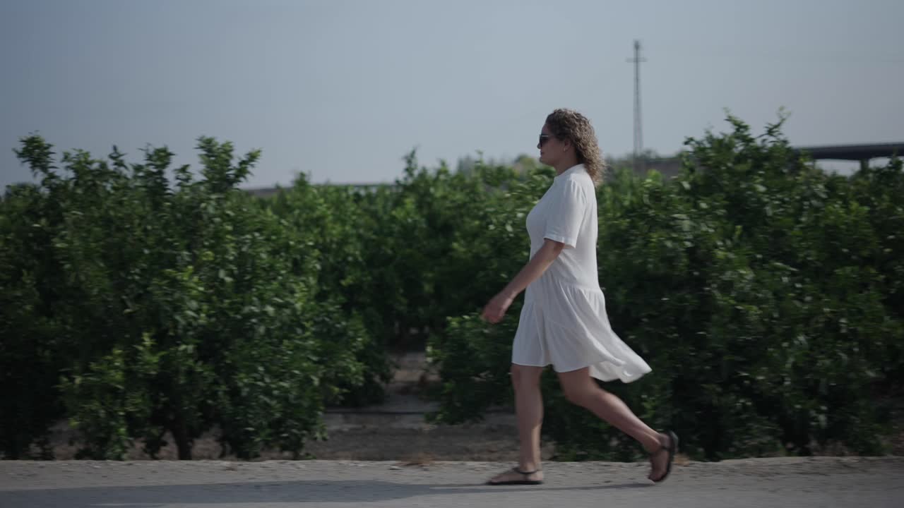 Woman walking in a citrus grove