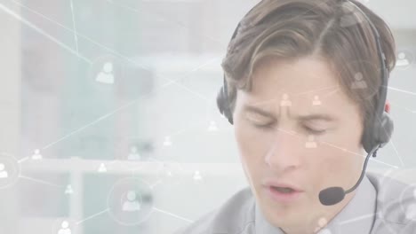 Animation-of-networks-of-connections-with-icons-over-businessman-using-phone-headsets