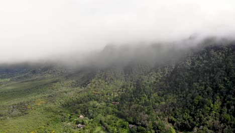 Cloudy-Valle-de-Anton-volcanic-crater-forest-covered-wall-in-central-Panama-remnant-of-extinct-volcano,-Aerial-pan-left-shot