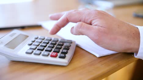 A person's hand typing into a calculator