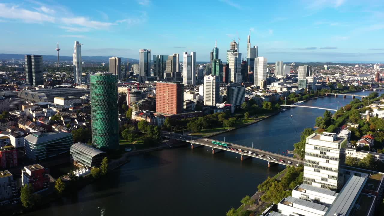 Carrellata aerea angolata in avvicinamento allo skyline di Francoforte, Germania, sopra il fiume Meno a mezzogiorno.