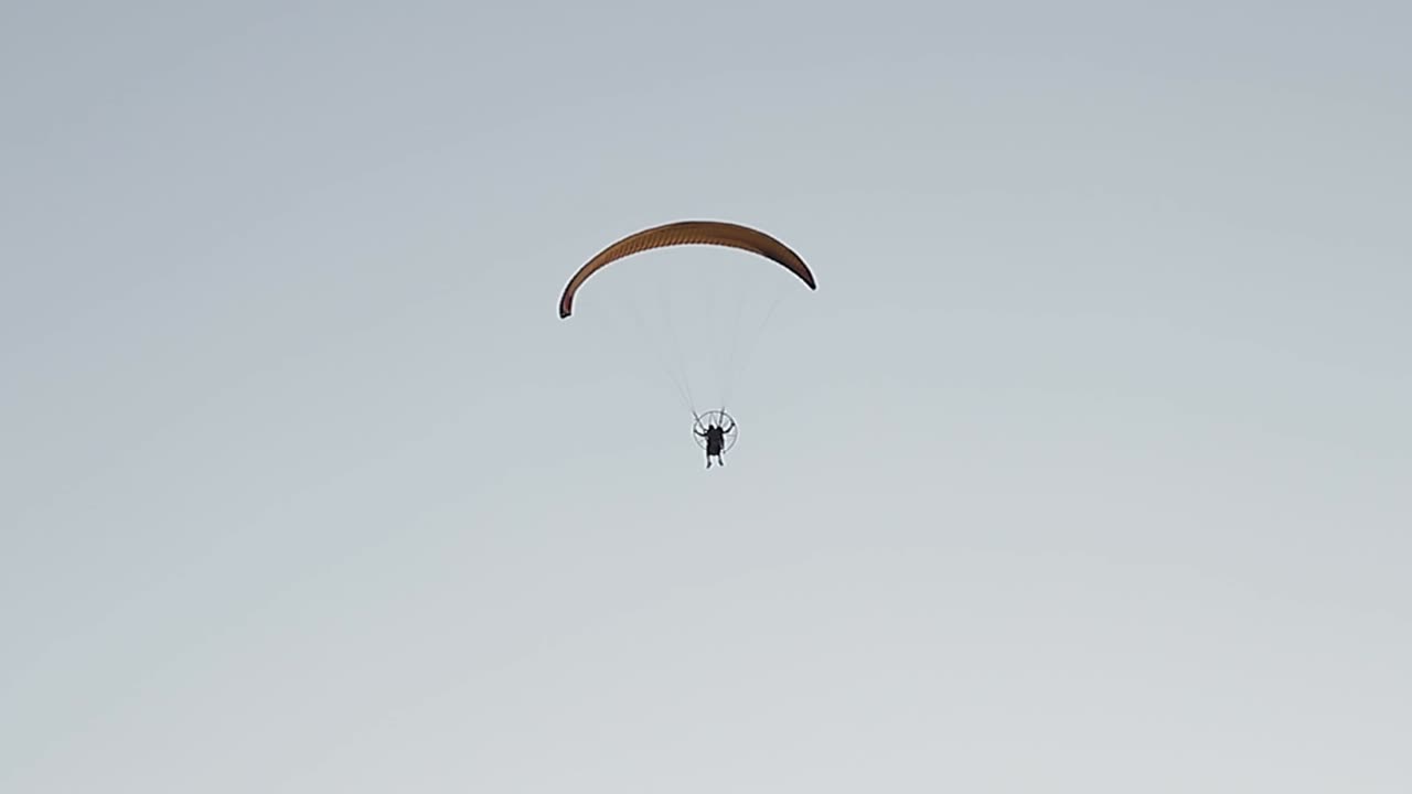 parapente volando sobre el cielo claro y soleado, deporte extremo