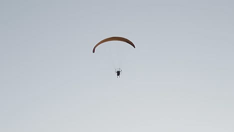 paragliding-flying-over-the-clear-and-sunny-sky,-extreme-sport