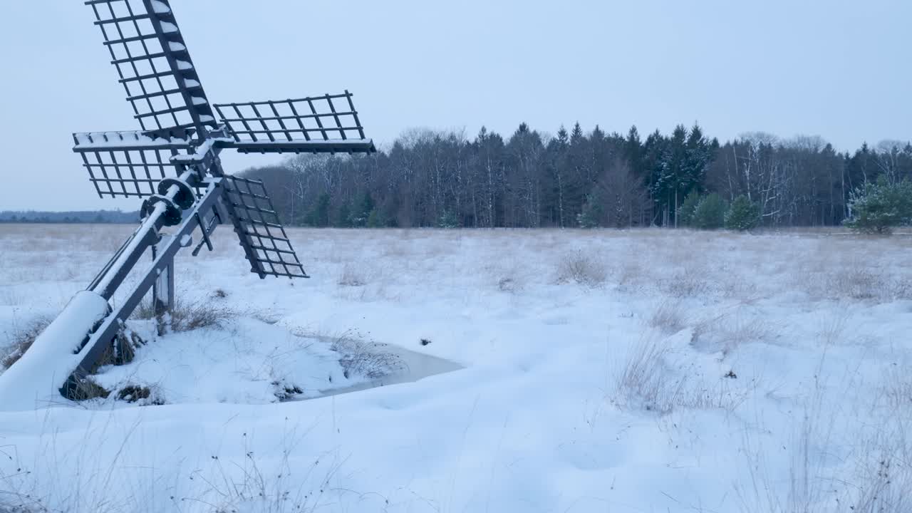Paesaggio invernale con mulino a vento ghiacciato