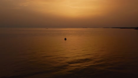 volando sobre un yate de vacaciones en un barco de pesca junto a la hermosa bahía costera de puesta de sol naranja y roja en el idílico mar mediterráneo adriático junto a la costa croata con islas