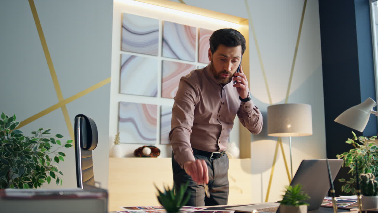 짜증나는 사업가 전화로 싸우고 사무실에 서서 긴장한 상사가 전화합니다.