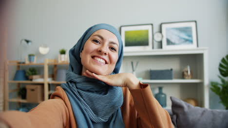 smiling woman taking a selfie in her living room
