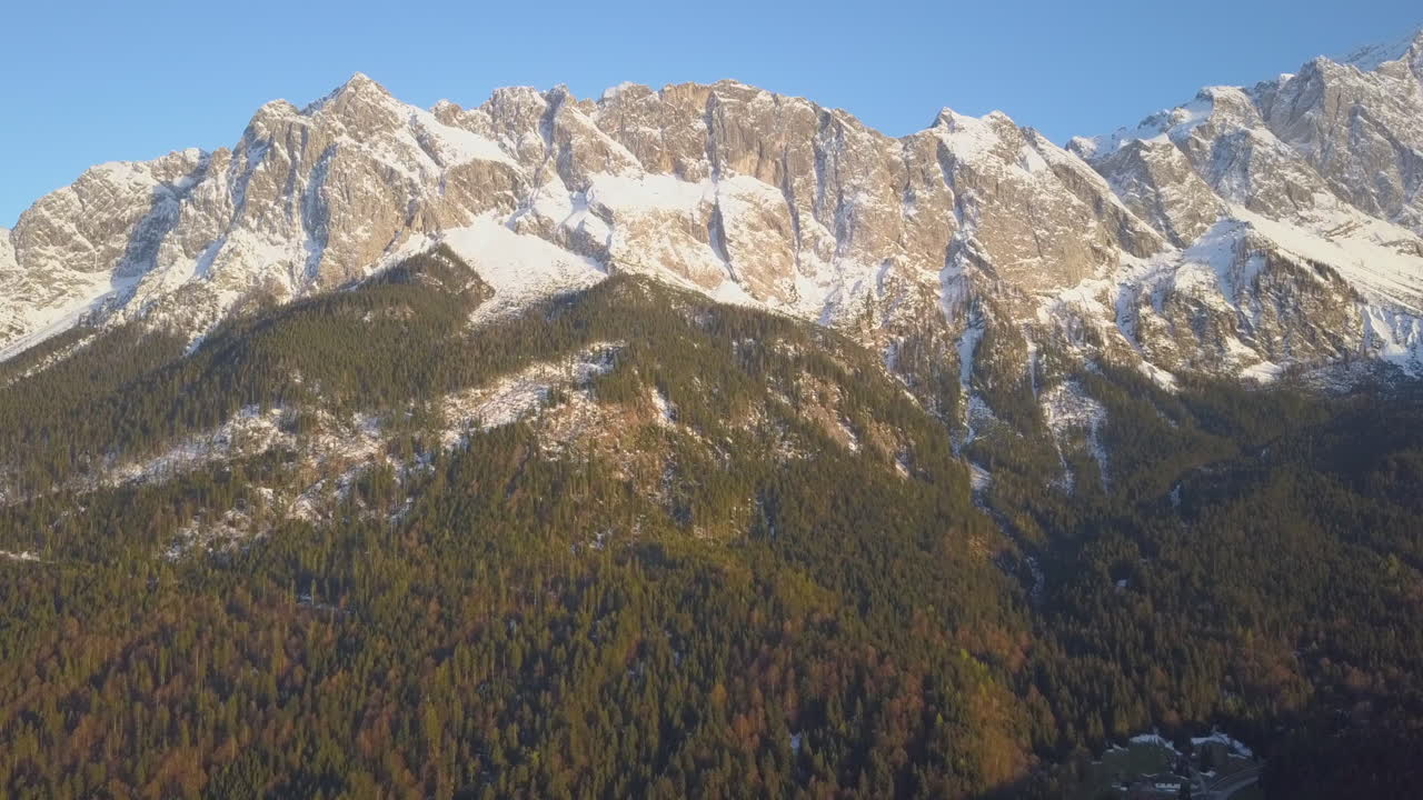 vista aérea volando hacia arriba zugspitze pintoresco punto de referencia nevado pico de la montaña alpina bajo un cielo azul