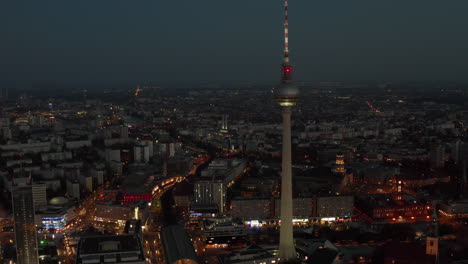 Amplia-Toma-De-Establecimiento-Por-Encima-De-La-Torre-De-Televisión-De-Berlín,-Alemania,-Alexanderplatz-Por-La-Noche-Con-Luces-De-La-Ciudad-Y-Tráfico,-Toma-Aérea