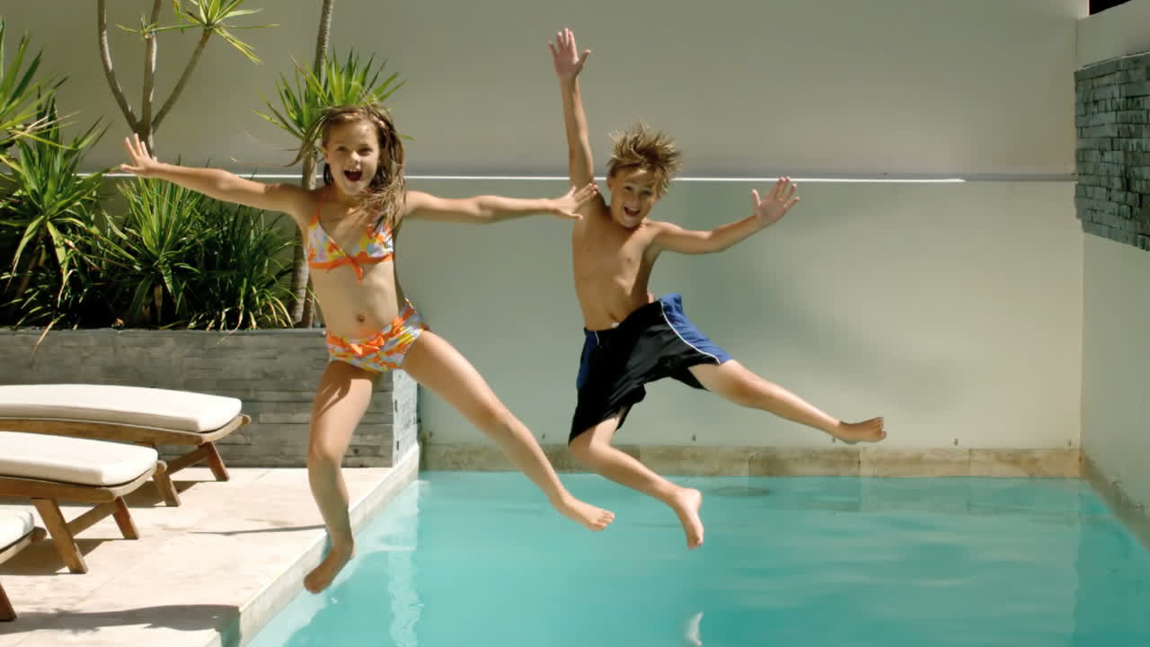 Fratelli felici che si tuffano in piscina