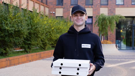 joven con cajas de pizza