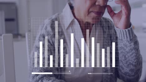 Animation-Von-Finanzdaten-über-Eine-ältere-Gemischtrassige-Frau,-Die-Einen-Laptop-Benutzt