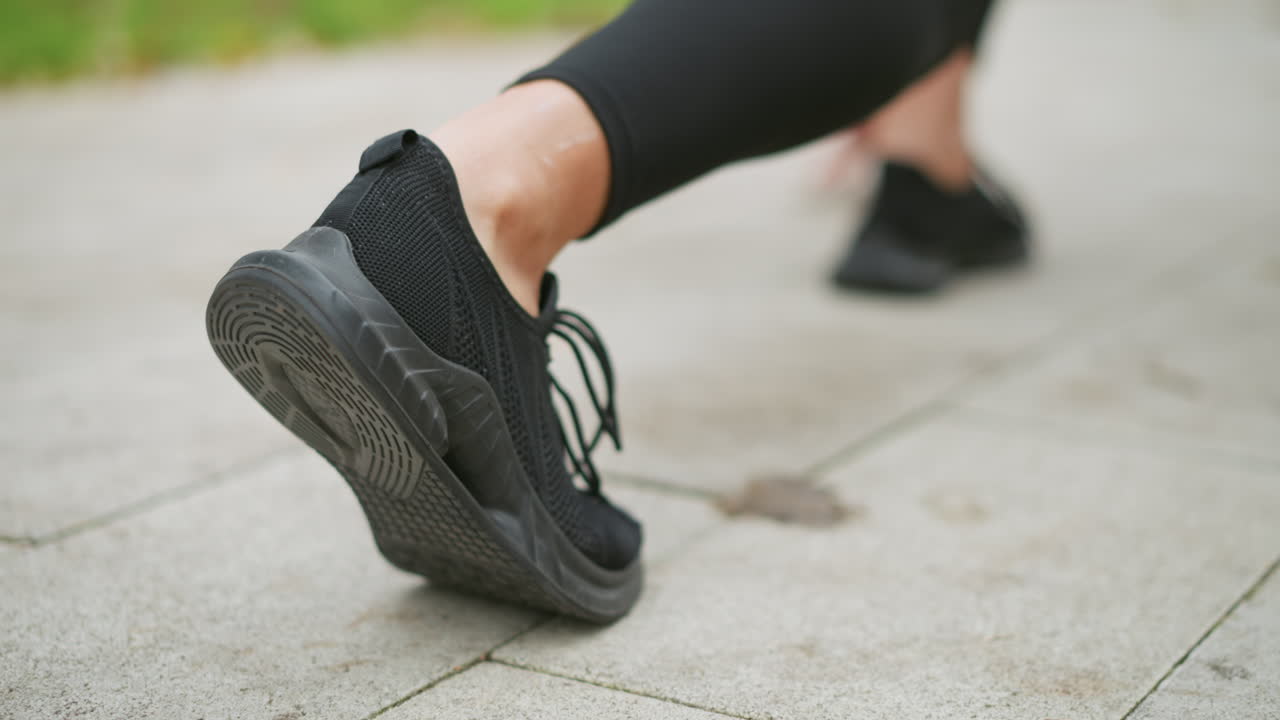 Back view of runner's leg in black sneakers taking off, athletic movement, sprinting, quick start, energy, powerful stride, workout action, fitness, dynamic motion, outdoor running