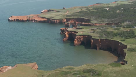 the magdalen islands with lush green meadow and fields by the saint lawrence river in northern quebec, canada