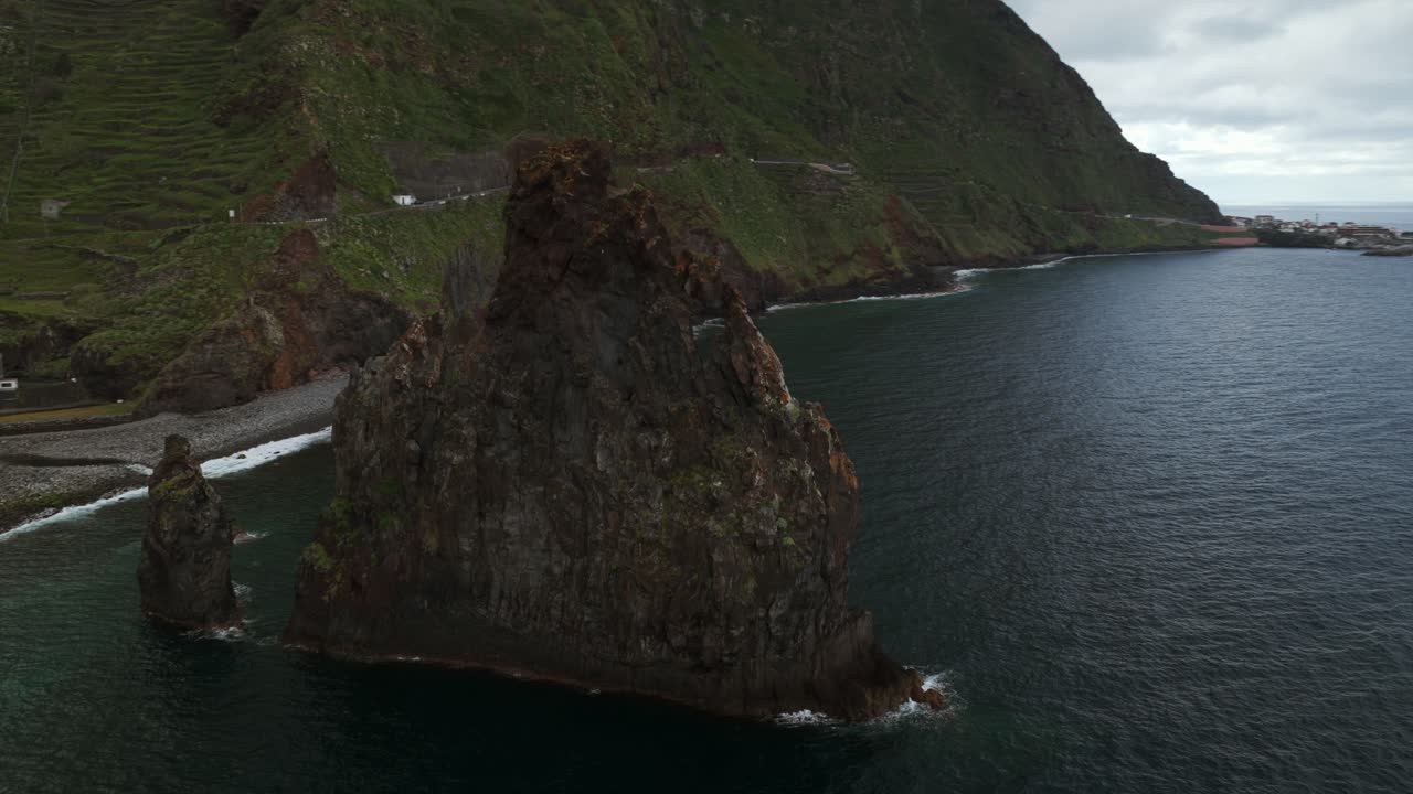 Ilhéus da Ribeira da Janela sea stacks, beach, cliffs, and Atlantic Ocean, Madeira, Portugal. Aerial drone orbiting