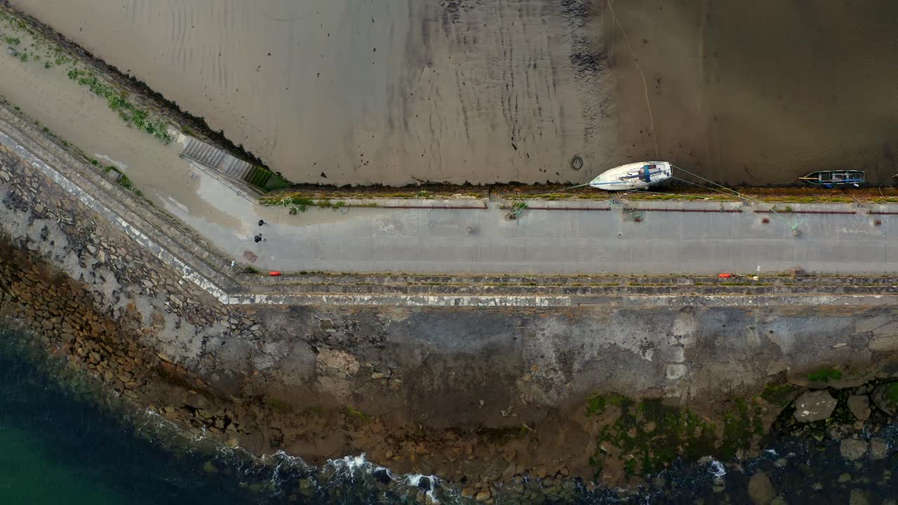 dos personas caminando por un pintoresco muelle irlandés