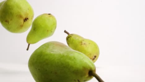 Whole-pears-bouncing-in-slow-motion-on-white-studio-backdrop-in-4k