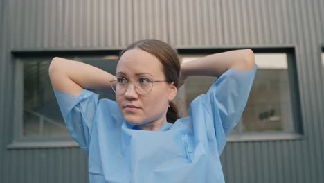 Mujer-Joven-Vestida-Con-Ropa-Médica-Preparando-El-Peinado-Para-La-Cirugía,-Vista-Frontal