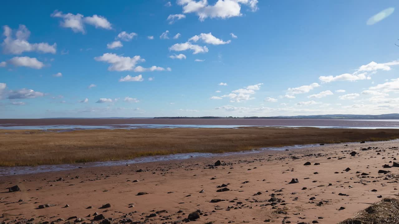 Timelapse of sunrise over the Minas Basin while the tide comes in a long way over the mud flats