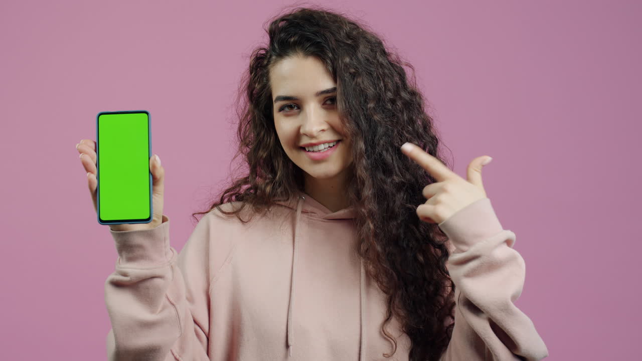 mujer sosteniendo un teléfono con pantalla verde