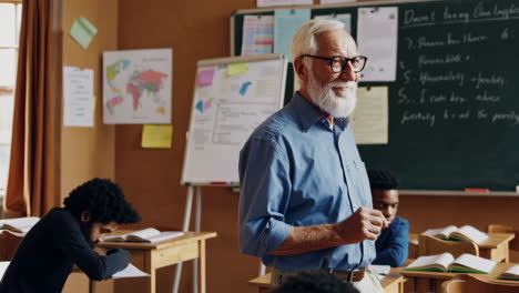 elderly teacher interacting with students in a classroom