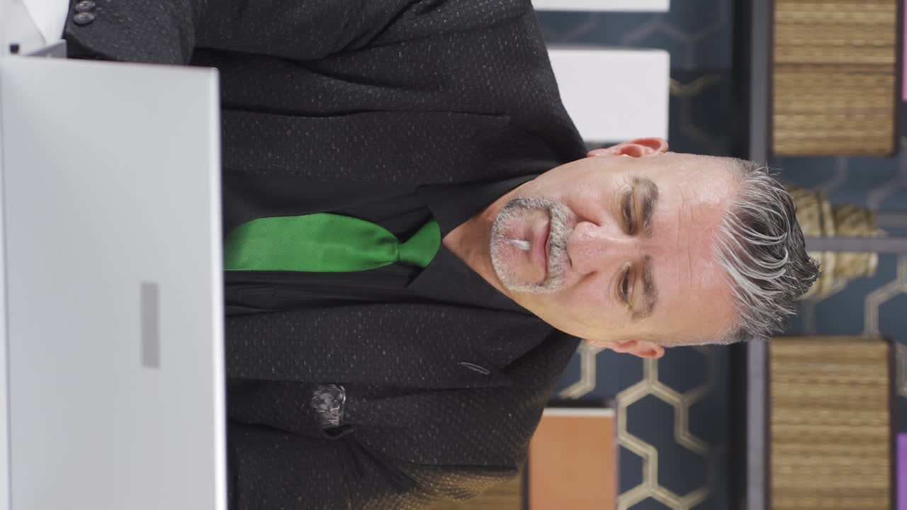 노트북을 사용하는 스트레스를 받은 사업가의 수직 비디오.