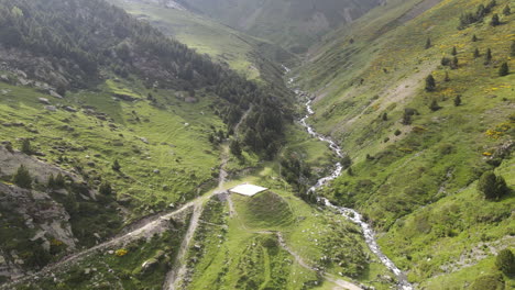 Toma-Aérea-De-Un-Hermoso-Río-Que-Fluye-Entre-Las-Verdes-Laderas-De-Dos-Montañas-En-Los-Pirineos