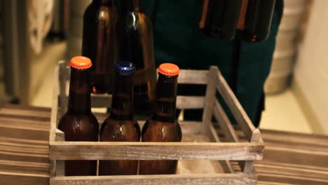 brewer putting beer bottle in beer crate at brewery