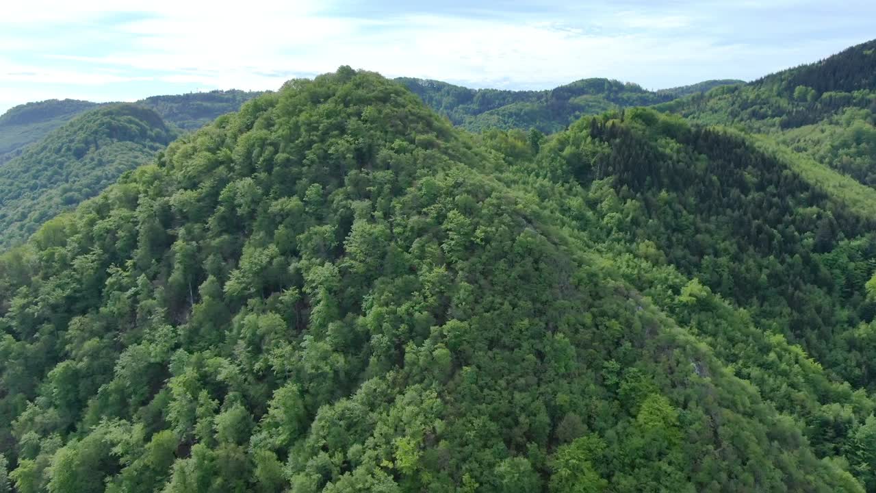 Wide angle dolly in drone shot of beautiful mountains and hills in Suhi Potok settlement in the Municipality of Kocevje in southern Slovenia