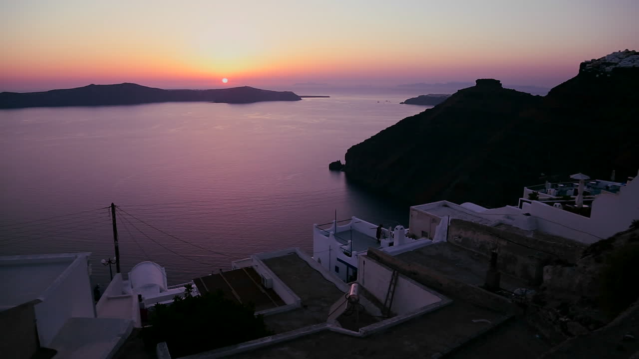 una asombrosa y hermosa puesta de sol detrás de una iglesia ortodoxa griega en la isla griega de santorini 7