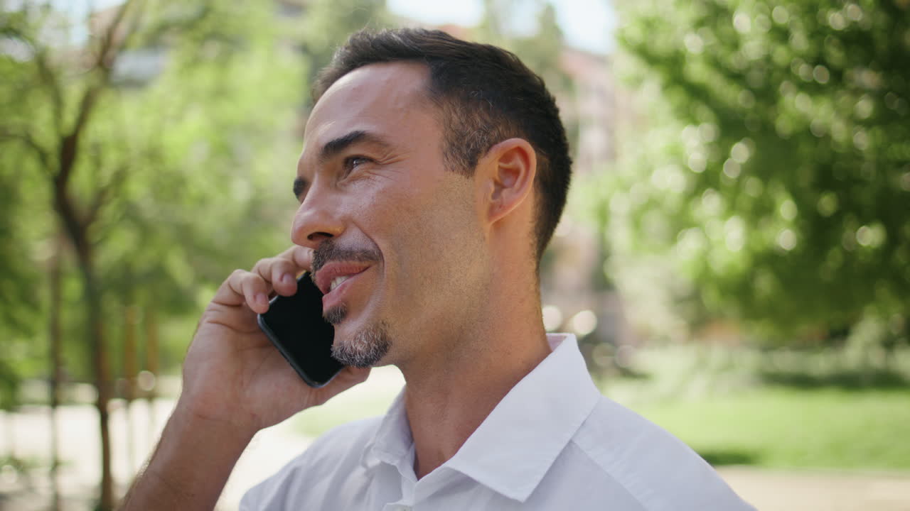 Joyful boss talking mobile phone summer greenery background closeup. Happy man