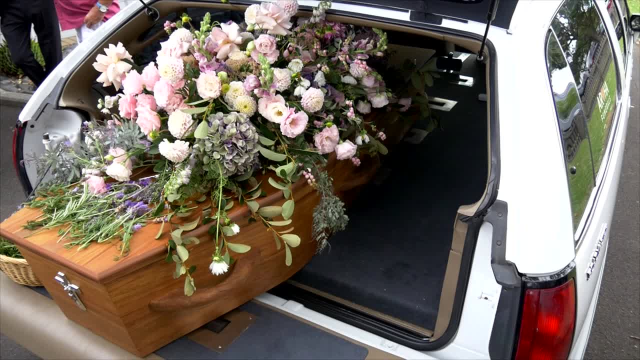 closeup shot of a funeral casket in a hearse or chapel or burial at cemetery