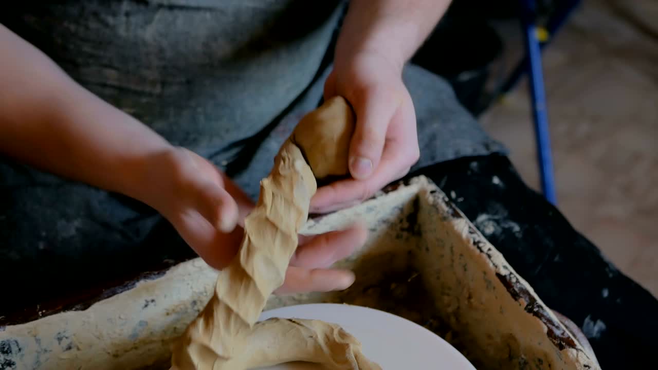 un alfarero profesional amasa arcilla en un taller de cerámica